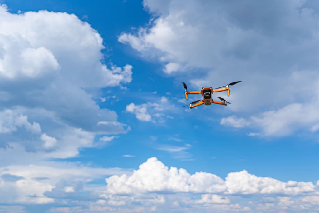 雲の浮かぶ青空を飛行する無人航空機
