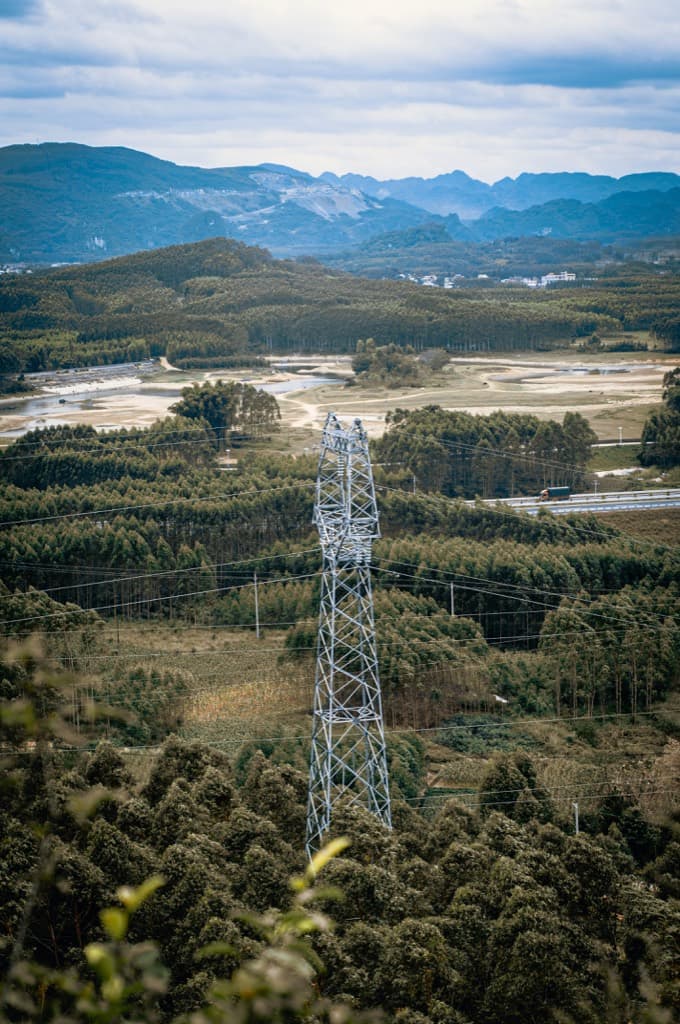 森に囲まれた造成地と送電鉄塔の俯瞰
